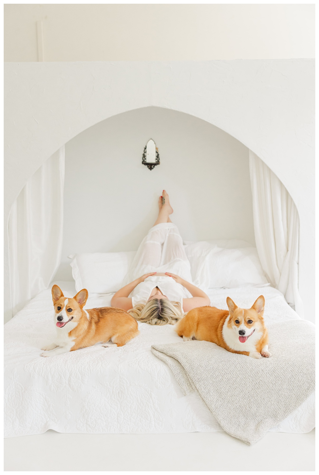 Hannah and Andrew sit on the bed with their dogs for their studio maternity photo shoot at The Rich Hippies House