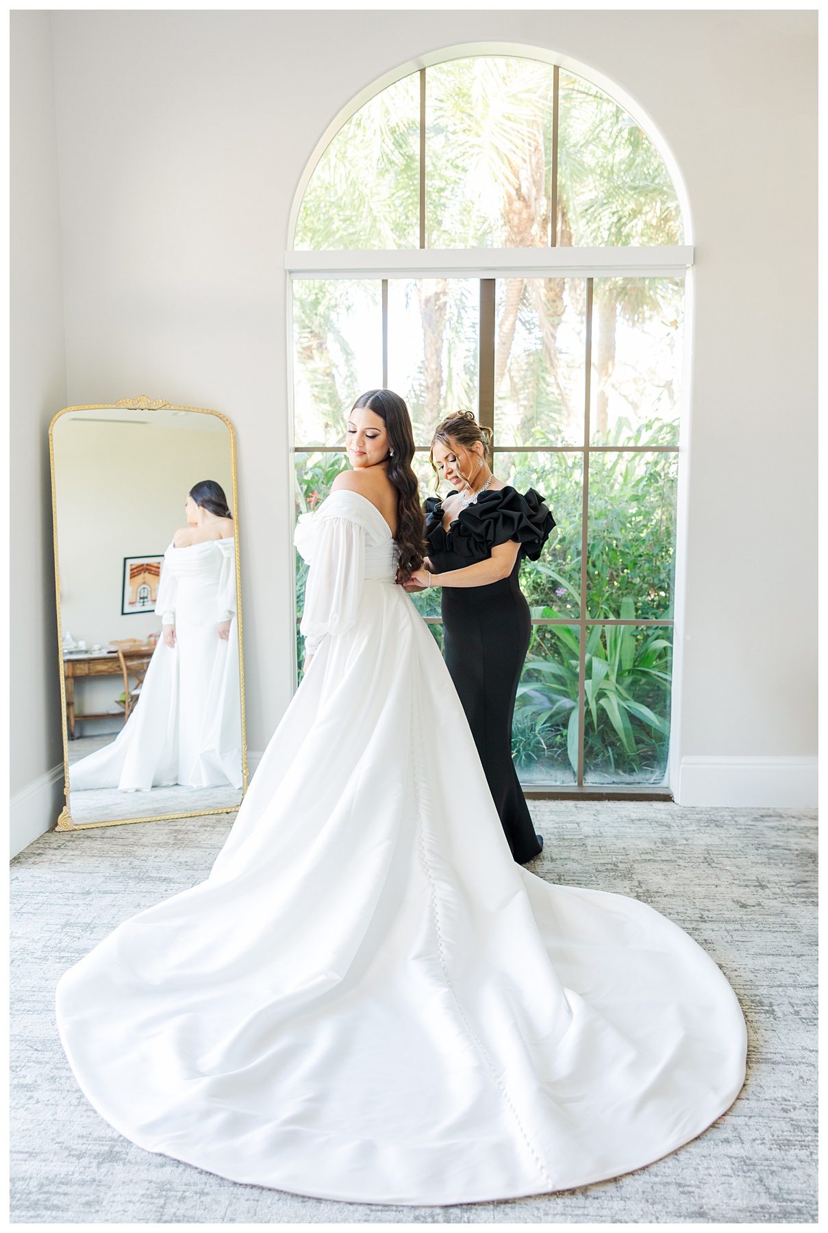 Bride getting into the dress with mom