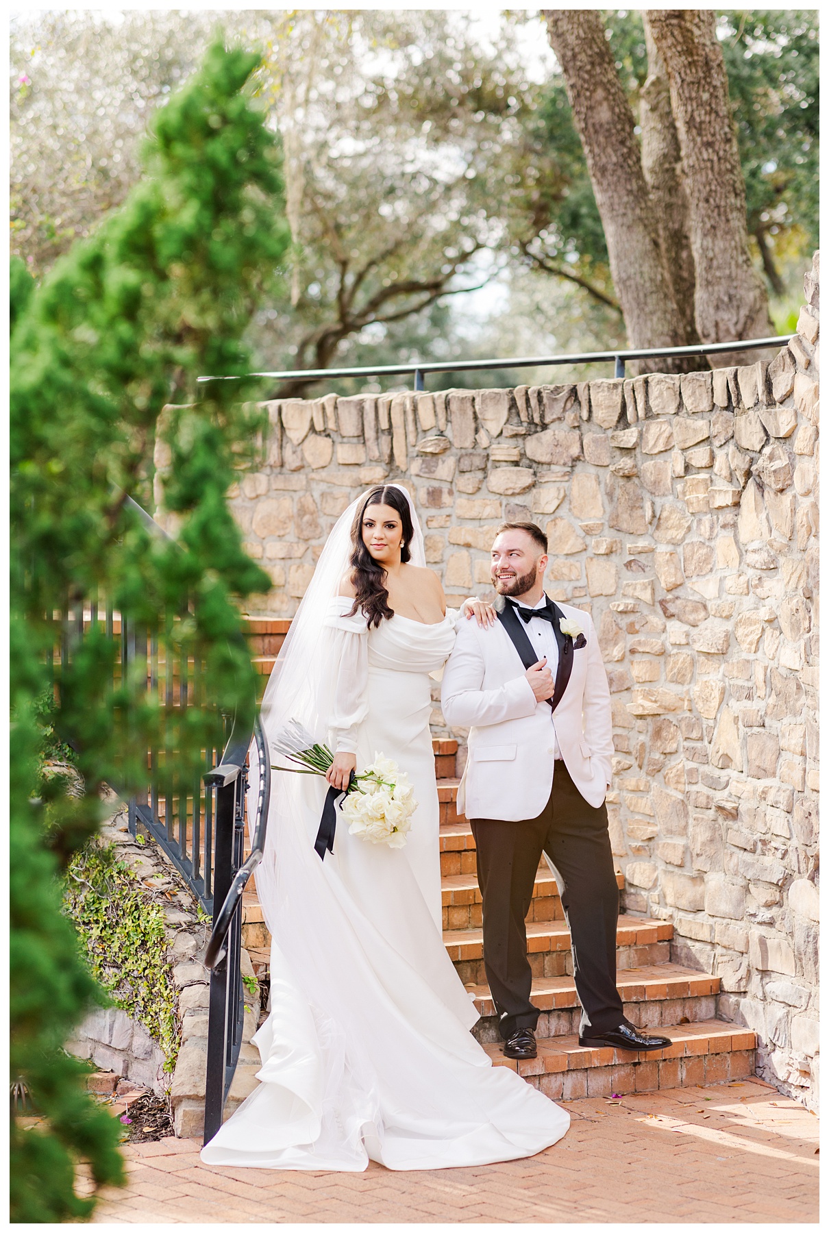 Bride and groom stand on the staircase at The Parkland Golf & Country Club