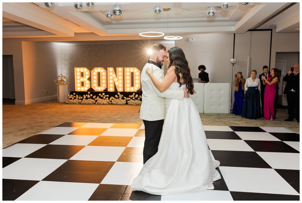 Bride and groom first dance on their checkered dance floor at The Parkland Golf and Country Club