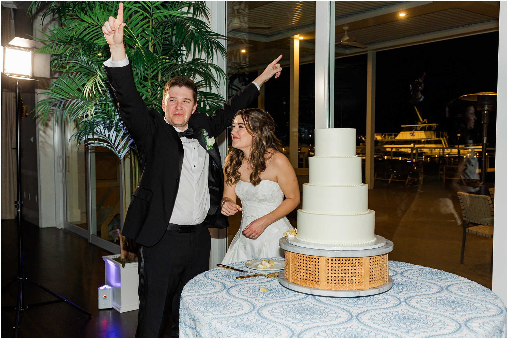 bride and groom cut their cake at their Pelican Club wedding reception